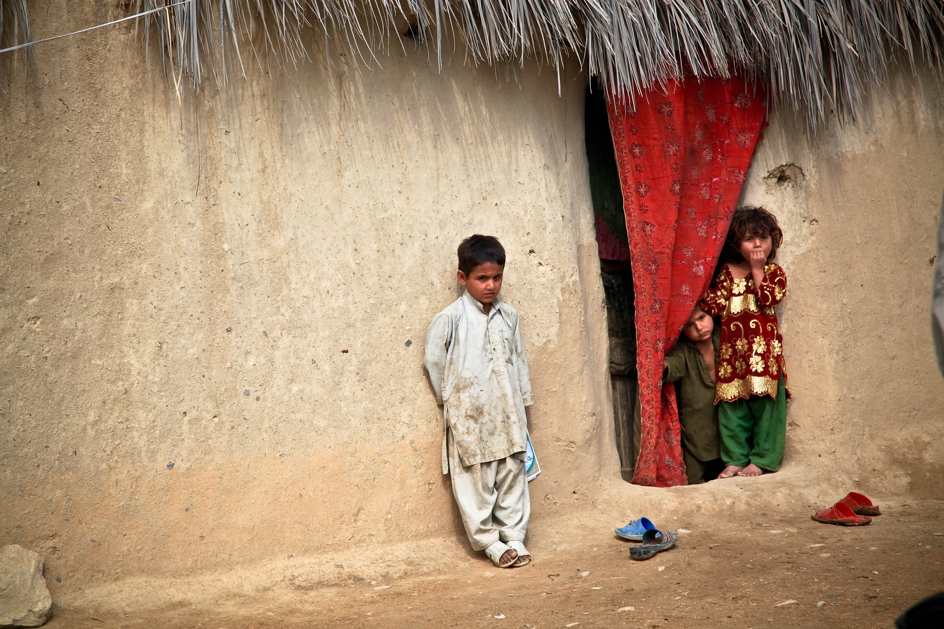 Afghan children leaning against a wall