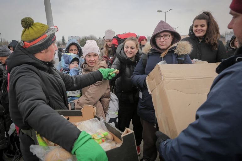 Volunteers give food, drinks, blankets, and diapers to babies, at the border crossing in Poland.