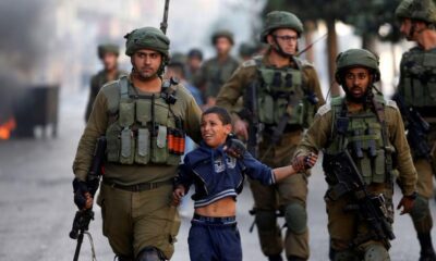IDF soldiers arresting a Palestinian child.