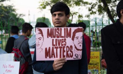 Man holding a banner that says Muslim Lives Matter.