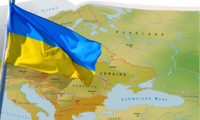 Ukraine flag over the map of world.
