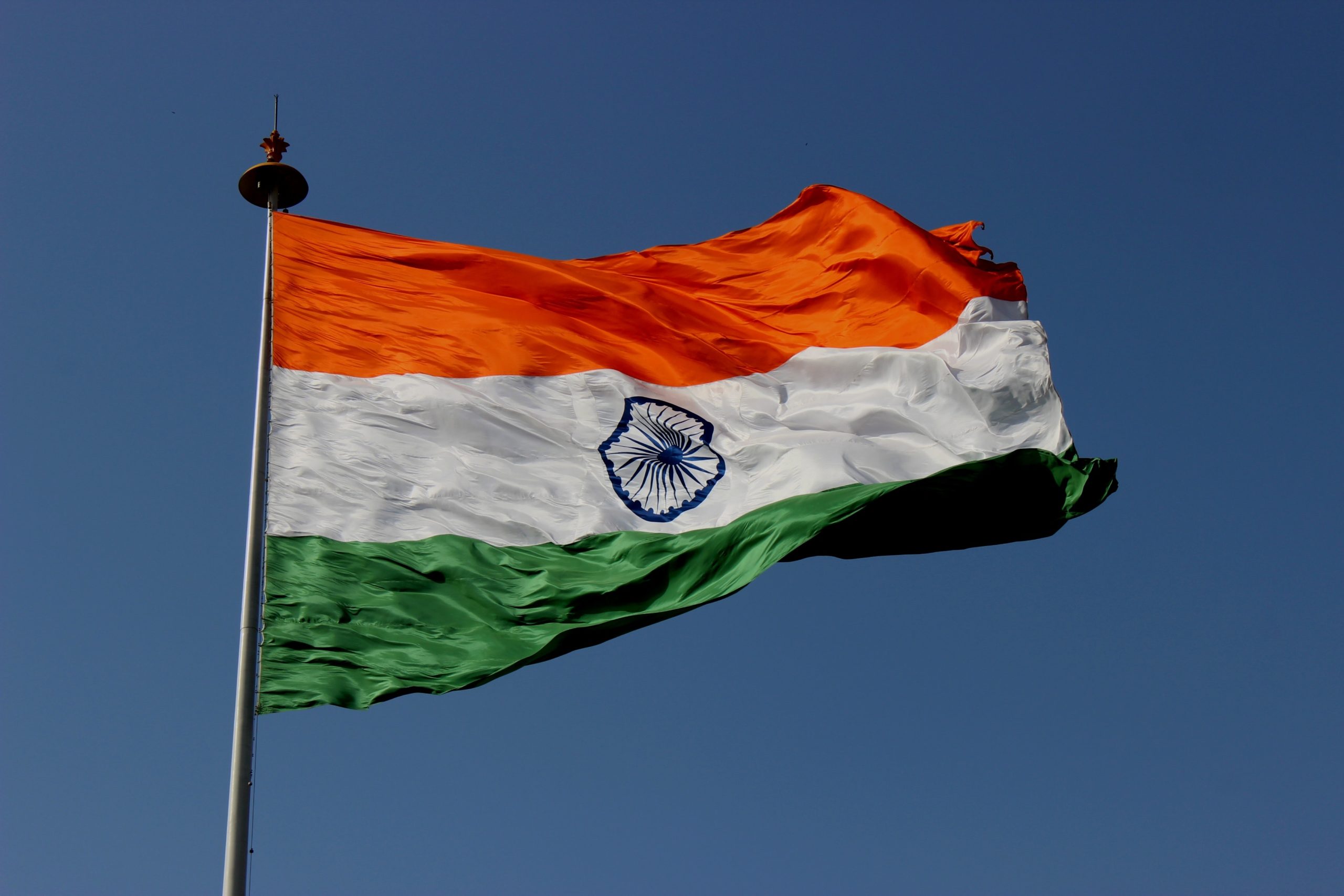 Indian flag swaying with blue sky in the background.