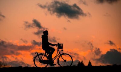 A man riding a bike and the sun is setting