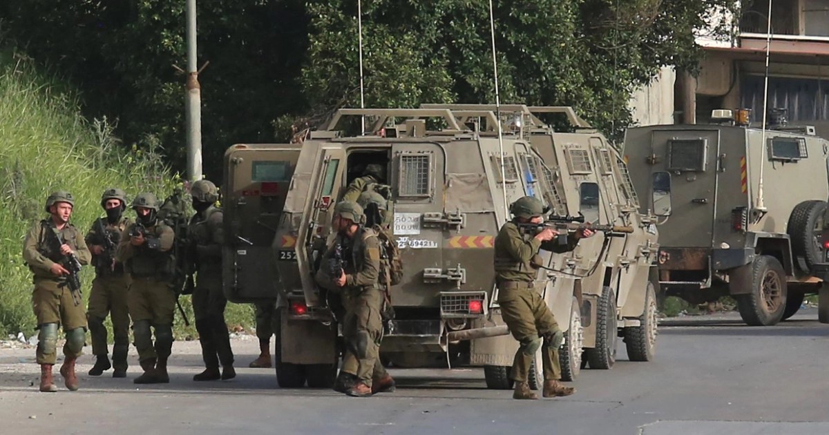 Israeli soldiers getting out of a military vehicle