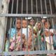 Children standing behind bars in a Jail.