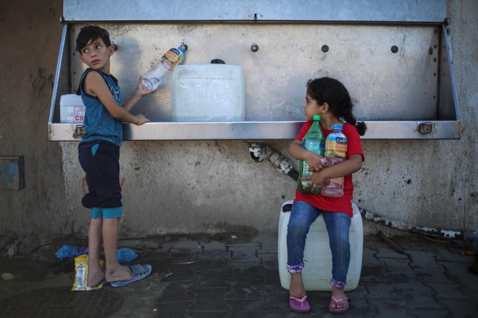 children filling up water bottle from a clean water source