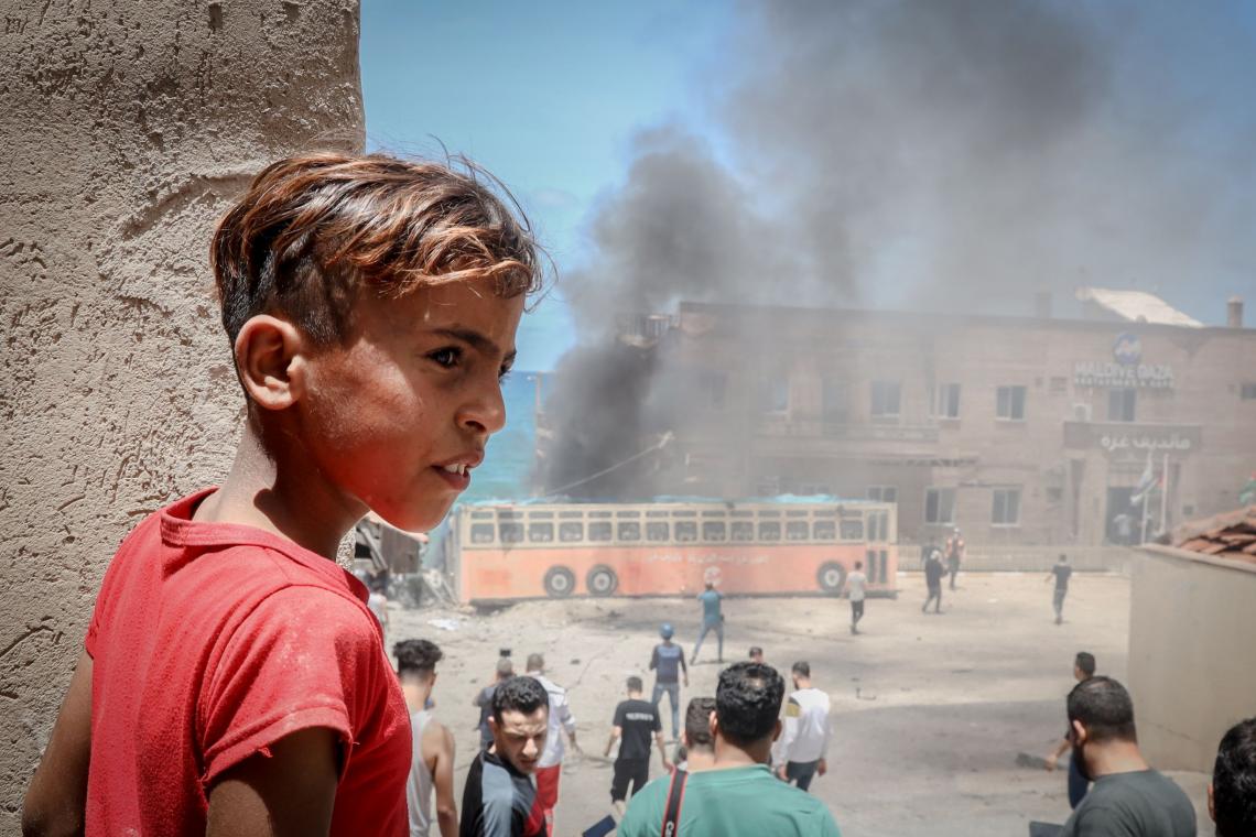 A child stands near a building in the port of Gaza that was damaged during an attack