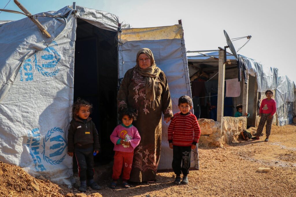 Caption: Sanaa with her children outside their tent in Fafin camp, northern rural Aleppo struggling to survive in Syria's humanitarian crisis © UNICEF/UN0401391/Almatar. 